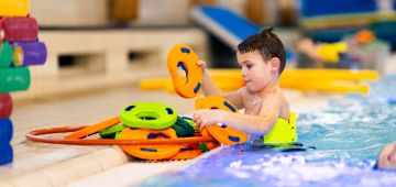 Kind met plankje zwemles